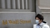 A person wearing a face mask walks along Wall Street after further cases of coronavirus were confirmed in New York City, New York, U.S., March 6, 2020. REUTERS/Andrew Kelly