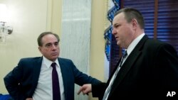 FILE - Veterans Affairs Secretary David Shulkin speaks with Sen. Jon Tester, D-Mont. (R), after testifying before the Senate Committee on Veterans Affairs on Capitol Hill, March 21, 2018, in Washington. 