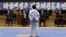 FILE - A North Korean participant in a national Taekwondo festival is judged in front of a sign in Korean that reads “National Taekwondo Festival for Celebrating Day of the Sun” at the Taekwondo Hall in Pyongyang, North Korea, April 7, 2012.