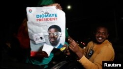 Supporters of Senegalese opposition leader Bassirou Diomaye Faye celebrate in the nation's capital, Dakar, on March 24, 2024, as preliminary results show he is leading in the elections, according to local media. 