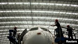 Trabajadores limpian el exterior de un avión en un hangar de la compañía de mantenimiento de la aerolínea Aeroman en San Luis Talpa, El Salvador. 29 de agosto de 2019. REUTERS/José Cabezas.