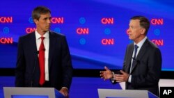 Former Texas Rep. Beto O'Rourke listens as former Colorado Gov. John Hickenlooper speaks during the first of two Democratic presidential primary debates hosted by CNN Tuesday, July 30, 2019, in the Fox Theatre in Detroit. (AP Photo/Paul Sancya)