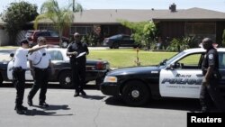 非洲裔美國人羅德尼.金的屍體被發現在家中的游泳池底﹐洛杉磯警員在他的屋外調查。