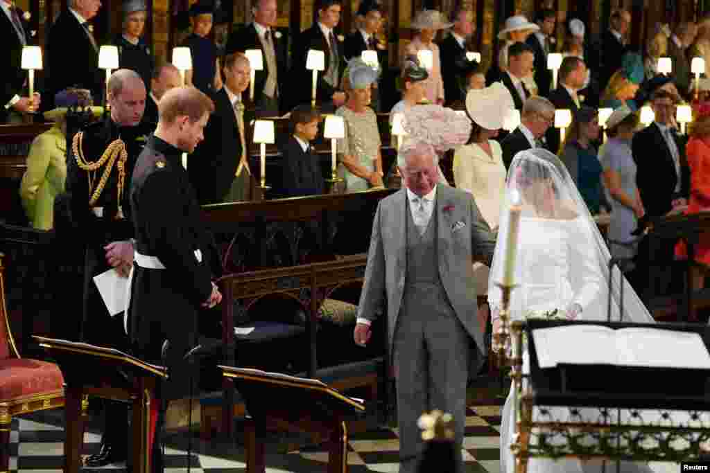 Pangeran Harry memandang pengantinnya, Meghan Markle, saat dia tiba didampingi Pangeran Charles (Prince of Wales) di Kapel Santo George, Istana Windsor, Inggris, 19 Mei 2018.