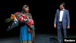 Malala Yousafzai bersama ayahnya, Ziauddin, di perpustakaan Birmingham, Inggris (10/10). (Reuters/Darren Staples)