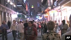 FILE - Tourists and locals walk down Bourbon Street in New Orleans