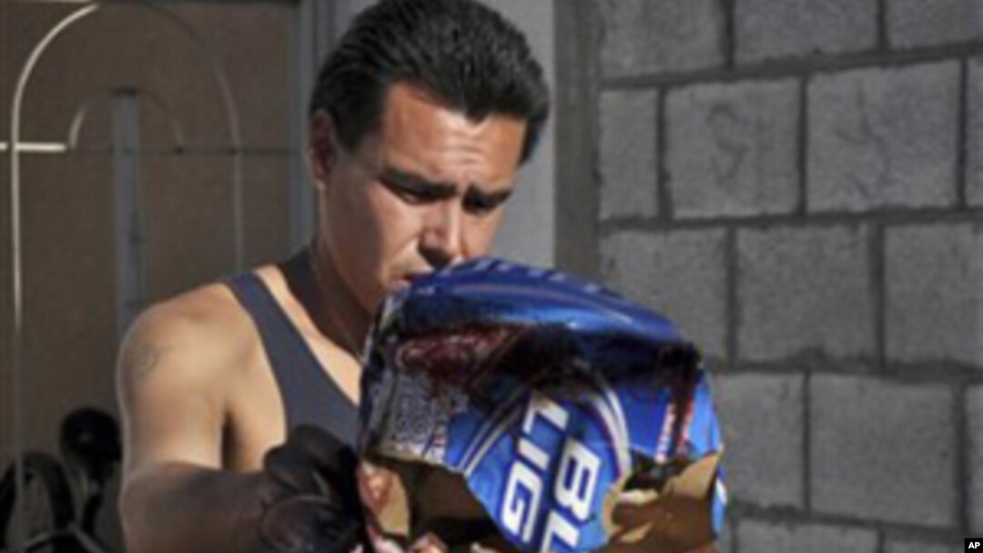 A man throws away blood stained items at a home in the northern city of Ciudad Juarez, Mexico, Saturday Oct. 23, 2010.
