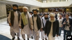 FILE - In this May 28, 2019 file photo, Mullah Abdul Ghani Baradar, the Taliban group's top political leader, third from left, arrives with other members of the Taliban delegation for talks in Moscow, Russia. U.S. envoy Zalmay Khalilzad and the Taliban ha