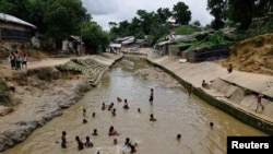 Sejumlah anak-anak Rohingya tampak bermain di sungai kecil di kamp pengungsi Kutupalang di Cox's Bazar, Bangladesh, pada 26 Juni 2024. (Foto: Reuters/Mohammad Ponir Hossain)