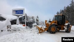 FILE - A plow clears snow after a heavy winter storm in Tahoe City, California, Jan. 11, 2017. 