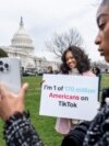 FILE - FILE - Devotees of TikTok, Mona Swain, center, and her sister, Rachel Swain, right, both of Atlanta, pose with a sign at the Capitol in Washington, March 13, 2024. 