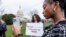 FILE - FILE - Devotees of TikTok, Mona Swain, center, and her sister, Rachel Swain, right, both of Atlanta, pose with a sign at the Capitol in Washington, March 13, 2024. 