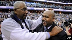 FILE - Former Georgetown coach John Thompson Jr., left, congratulates his son Georgetown head coach John Thompson III, right, after the Hoya's 61-39 win over Syracuse in an NCAA college basketball game in Washington, March 9, 2013.