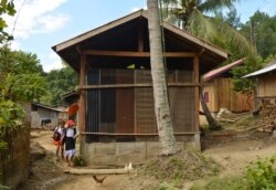 Girls walk home from school in Khokkham village, Laos, Nov. 4, 2019. (Zsombor Peter/VOA)