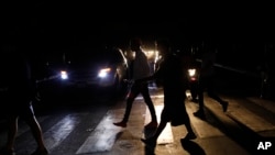 People walk on a street during a blackout in Caracas, Venezuela, July 22, 2019. When much of Venezuela was plunged into darkness earlier in the week, Maduro blamed the power outage on an “electromagnetic attack” carried out by the United States.