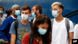 People wearing a face masks to prevent the spread of coronavirus wait to board a ferry in the port of Piraeus, near Athens, on Friday, Aug. 7, 2020. Young people "are not invincible", the World Health Organization (WHO) officials said a week ago…