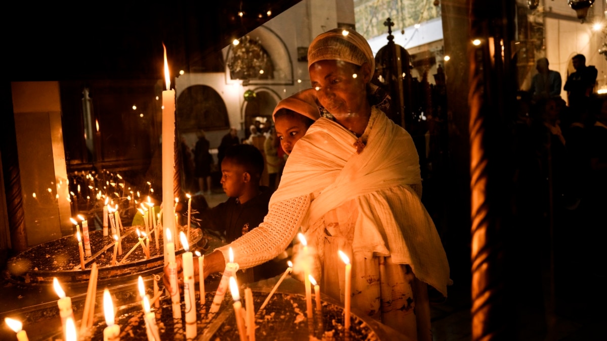 A Palestinian boy poses behind candles during a power outage