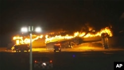 Bomberos tratan de sofocar el incendio que consumió el avión de pasajeros de Japan Airlines este martes en Tokio al chocar con otro avión pequeño de la Guardia Costera japonesa.