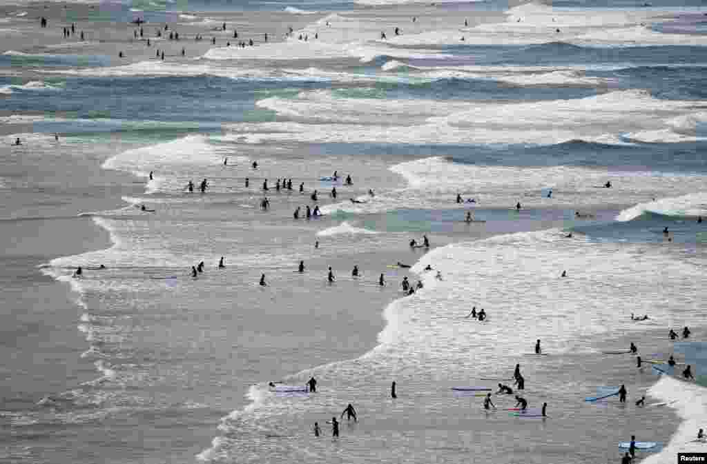 Surfers are seen in the sea ahead of the G-7 Summit on the French coastal resort of Biarritz, France.