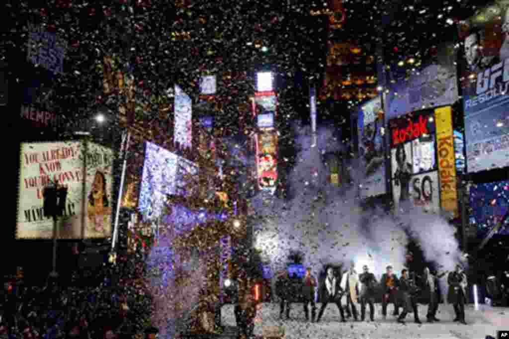 While confetti falls, the New Kids on the Block and the Backstreet Boys perform for the crowds awaiting the new year in Times Square in New York, 31 Dec 2010. (AP Image)