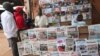 FILE - People read local newspapers with election headlines in Yaounde, Cameroon.