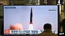 A man watches a television screen at Suseo railway station in Seoul showing news footage of North Korea's latest tactical guided projectile test.