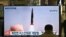A man watches a television screen at Suseo railway station in Seoul showing news footage of North Korea's latest tactical guided projectile test.