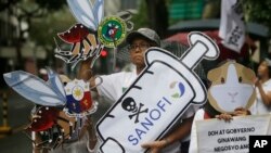 Para demonstran menunjukkan slogan dalam demonstrasi memprotes program pemberian vaksin antidengue Dengvaxia terhadap lebih dari 700.000 anak Filipina di Manila, Filipina, 18 Desember 2017. Vaksin kontroversial itu dibuat oleh Sanofi Pasteur