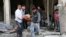This photo provided by the anti-government activist group Aleppo Media Center (AMC), an anti-Bashar Assad activist group, which has been authenticated based on its contents and other AP reporting, shows Syrian men carrying a covered dead body after a government airstrike attack in the al-Mayssar neighborhood, in Aleppo, April 3, 2014.