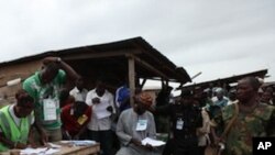 Soldiers and police stand guard as electoral officials count ballot papers after the National Assembly election in Ibadan, Nigeria,Saturday, April 9, 2011.