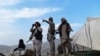 FILE - Afghan militia fighters keep watch at an outpost against Taliban insurgents at Charkint district, Balkh province, Afghanistan, July 15, 2021. 