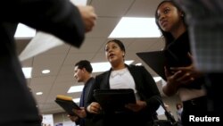 FILE - Job seekers listen to prospective employers during a job hiring event for marketing, sales and retail positions in San Francisco, California, June 4, 2015.