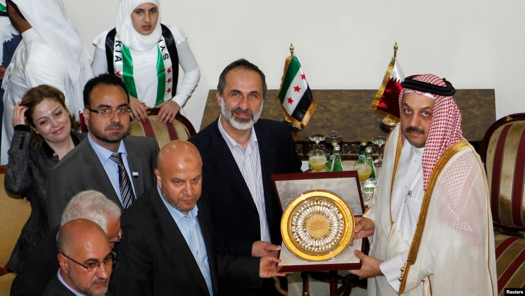 Suriya muxolifati vakili Muaz al Xatib, Qatar Tashqi ishlar vaziri Xolid bin Muhammad al-Attiya Doxadagi elchixonaning ochilish marosimida.