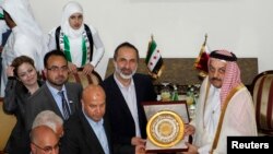 시리아 반군 연합의 모아즈 알카티브 대표(가운데)가 27일 카타르 도하에서 새 시리아 대사관 현판을 칼리드 빈 모하메드 알아티야 카타르 외무장관에게 전달하고 있다. 카타르를 포함한 아랍연맹은 시리아 반군 연합을 시리아의 유일한 대표로 인정했다.