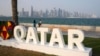 Dua orang difoto di Doha Corniche di depan kaki langit modern sehari sebelum dimulainya Piala Dunia Sepak Bola di Doha, Qatar, Sabtu, 19 November 2022. (Foto: AP/Martin Meissner)