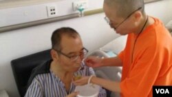 FILE - Chinese dissident and Nobel Prize laureate Liu Xiaobo, left, is attended to by his wife Liu Xia in a hospital in China. 