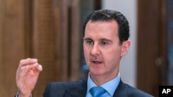 FILE - In this photo released June 13, 2018, by the Syrian official news agency SANA, Syrian President Bashar al-Assad speaks during an interview with Iran's Al Alam TV, in Damascus, Syria.