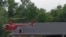 This image from video provided by Jeani Rice-Cranford shows Nashville-based helicopter pilot Joel Boyers rescuing people from a rooftop, in Waverly, Tennessee, Aug. 21, 2021.