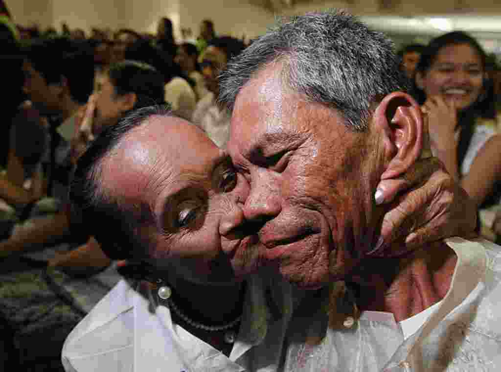 Seorang pengantin perempuan berusia 66 tahun mencium pipi suami barunya yang berusia 54 tahun dalam sebuah upacara pernikahan massal dalam rangka hari Valentine di Paranaque, Metro Manila, 14 Februari (REUTERS).