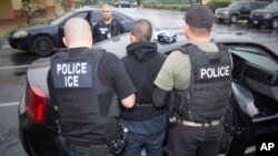 FILE - This photo released by U.S. Immigration and Customs Enforcement shows foreign nationals being arrested, Feb. 7, 2017, during a targeted enforcement operation conducted by U.S. Immigration and Customs Enforcement (ICE).