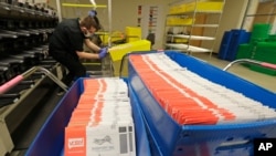 Vote-by-mail ballots are shown in sorting trays, Wednesday, Aug. 5, 2020, at the King County Elections headquarters in Renton, Wash., south of Seattle.