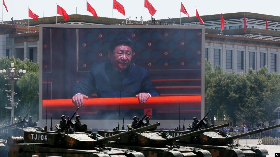 Chinese President Xi Jinping is displayed on a big screen as Type 99A2 Chinese battle tanks roll across during a parade commemorating the 70th anniversary of Japan's surrender during World War II from Tiananmen Gate, in Beijing, Sept. 3, 2015.