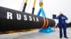 Seorang pekerja konstruksi Rusia berbicara di telepon seluler saat dimulainya pembangunan pipa Nord Stream di Teluk Portovaya sekitar 170 km barat laut dari St. Petersburg, Rusia, 9 April 2010. (Foto: AP)