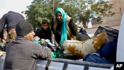 Iraqi security forces and allied Sunni tribal fighters help trapped civilians get to safer areas, in Ramadi, 70 miles (115 kilometers) west of Baghdad, Iraq, on Jan. 2, 2016.