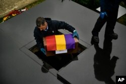 A man carries one of the 46 coffins of unidentified people killed during the Spanish Civil War, at San Jose cemetery, Pamplona, northern Spain, April 1, 2019.