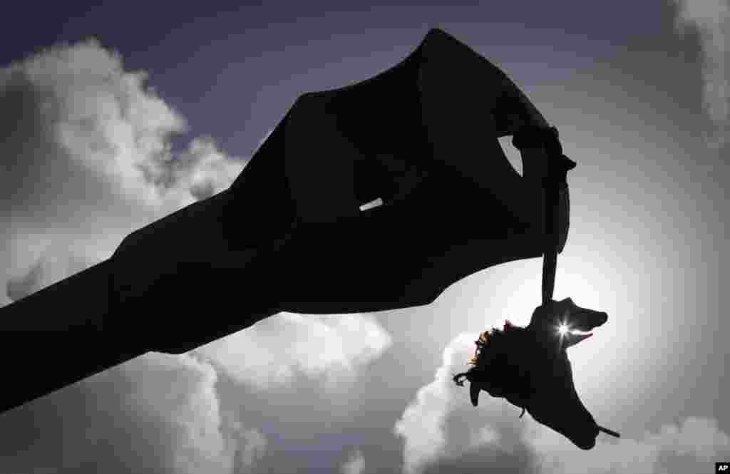 The head of a goat with a cigarette in his mouth hangs from the barrel of a tank belonging to the forces of Moammar Gadhafi on the outskirts of Benghazi, eastern Libya, Sunday, March 20, 2011. The tanks were destroyed earlier by NATO plans. The U.S. milit