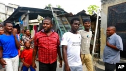 FILE - Barbecue, whose real name is Jimmy Cherizier, center left, walks as residents chant "Barbecue for life" in his neighborhood in Lower Delmas, a district of Port-au-Prince, Haiti, May 24, 2019.