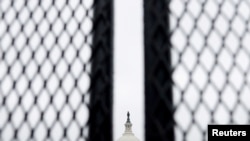 FILE - Security fences, erected following the January 6th attack, are seen surrounding the U.S. Capitol in Washington, March 24, 2021. 