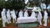 Health officials wearing personal protection equipment prepare to bury coronavirus victim Dr. Doreen Adisa Lugaliki at her burial in Ndalu, Bungoma county, Kenya ,July 13, 2020. 