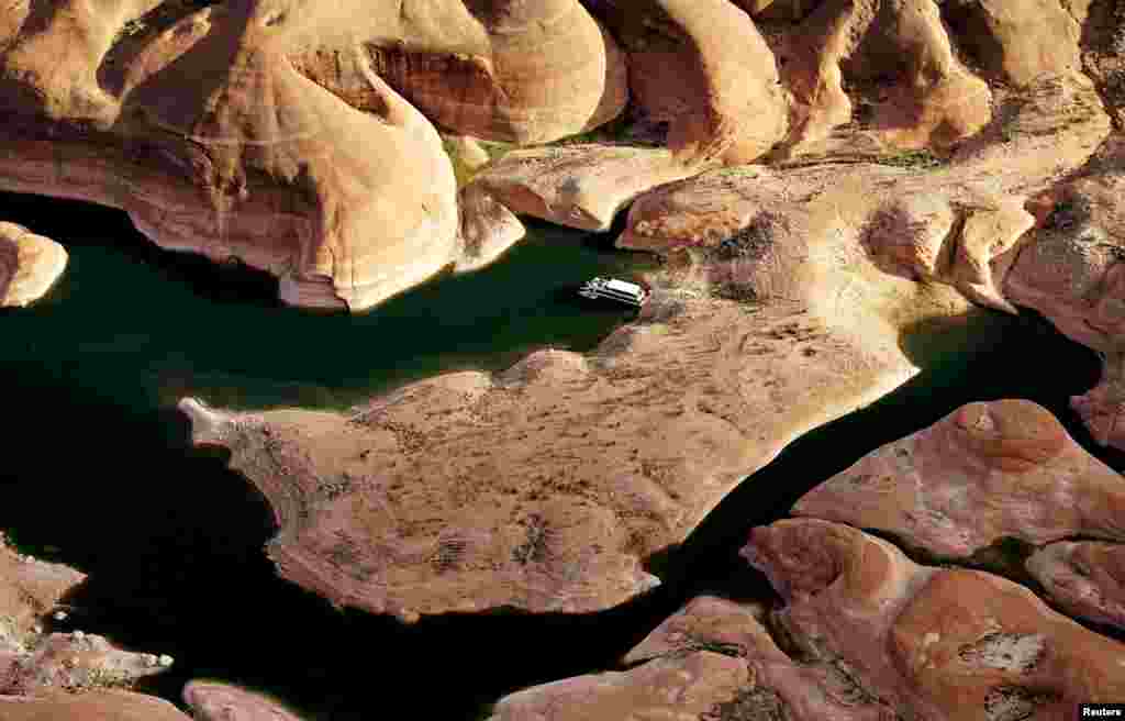 A houseboat camps on the shore in shallow water in a canyon at Lake Powell near Page, Arizona, USA, May 26, 2015.